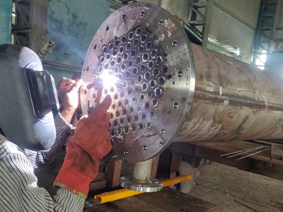 Welder TIG welding tube to tubesheet joints on a stainless heat exchanger