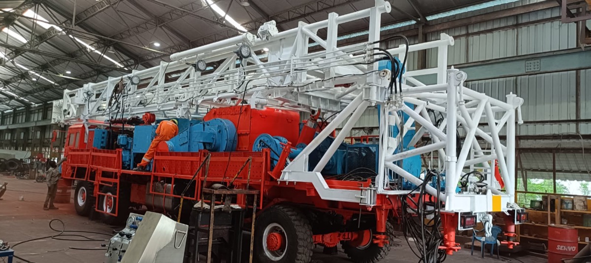 Truck-mounted workover rig freshly painted red and white in the SPCS workshop