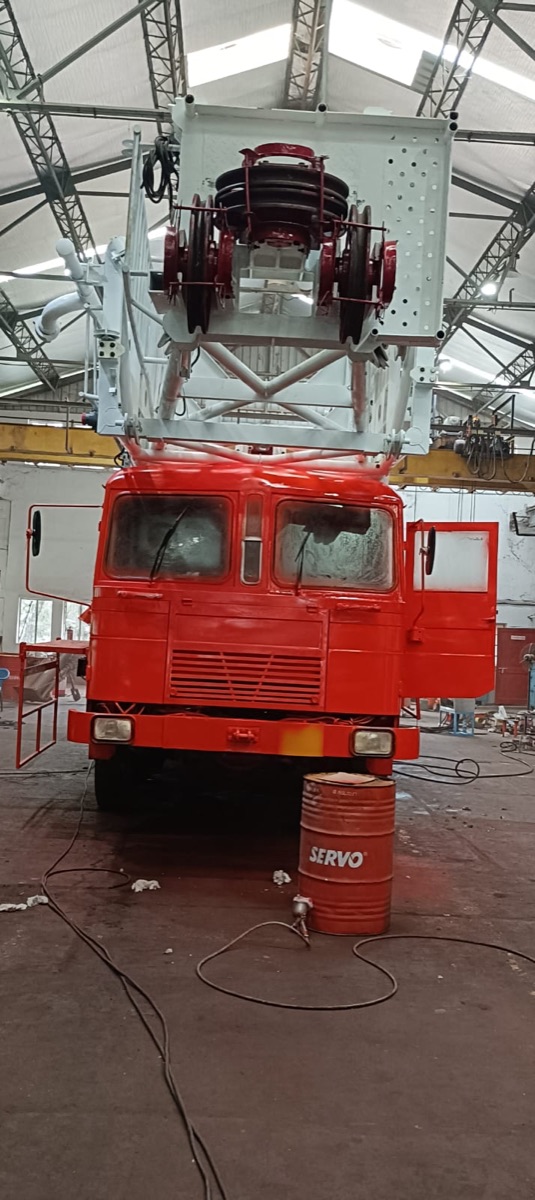 Front view of the repainted workover rig cab and mast assembly