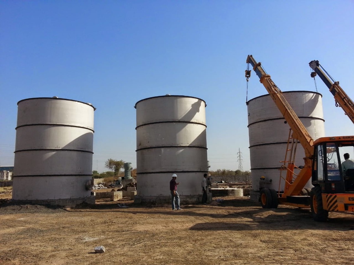 Three stainless storage vessels erected on site with a mobile crane alongside
